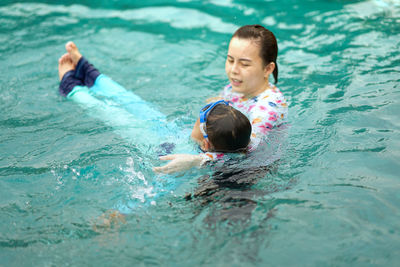 High angle view of mother and boy swimming in pool