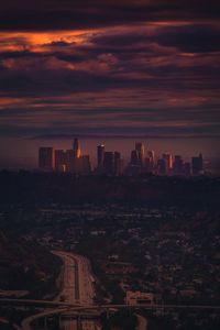 Modern buildings in city against sky during sunset