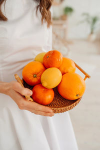 Close-up of woman holding orange fruit