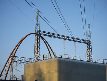 A closeup of an electric distribution station with electric wires connected to the pylons.