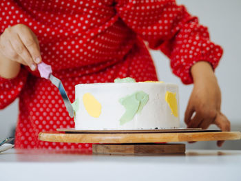 Close-up of woman hand holding ice cream on table