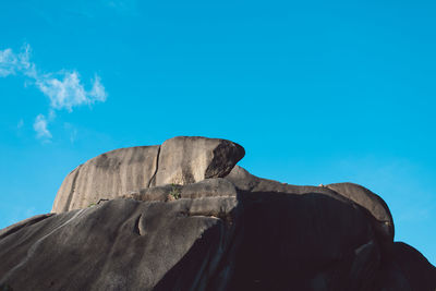 Low angle view of rock against blue sky