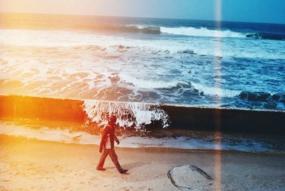 Full length of man standing on beach against clear sky