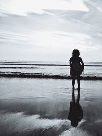 Rear view of man standing on beach