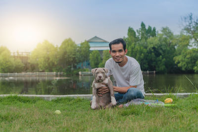 Young man with dog standing on grass