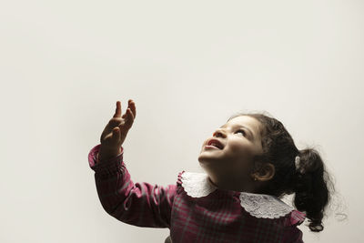 Portrait of girl looking up against white background