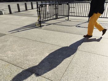 Low section of woman with shadow on sunny day