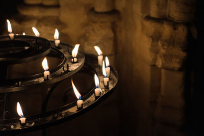 Close-up of lit candles in dark room