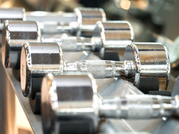 Close-up of silver colored dumbbells on rack