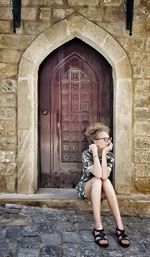 Full length of woman with closed door of building