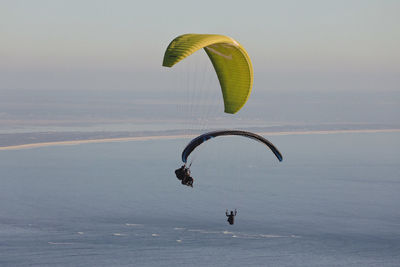 Low angle view of person paragliding against sky