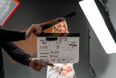 Woman gestures with clapper board in front of man, creating fun event display