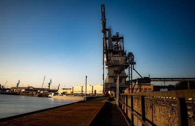 Commercial dock against clear sky during sunset