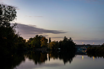 Scenic view of lake against sky at sunset