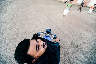 High angle portrait of man holding umbrella on street in city