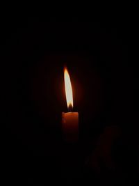 Close-up of burning candle in darkroom