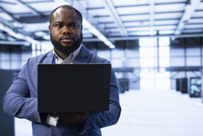 Portrait of man using digital tablet at office
