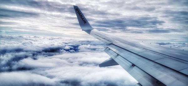 Airplane flying over cloudscape against sky