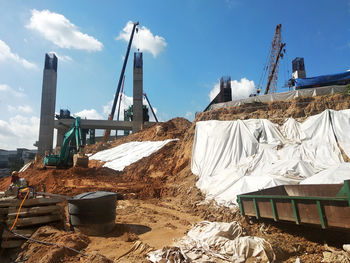 Stack of construction site on field against sky