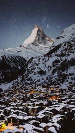 Aerial view of snowcapped mountains against sky at night