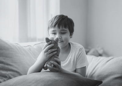Boy sitting on bed at home