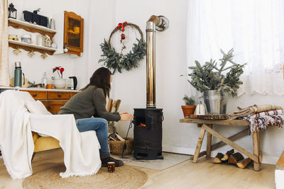 Rear view of woman sitting on sofa at home