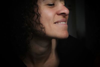 Close-up portrait of smiling young woman looking away