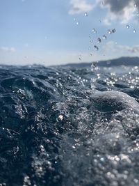 Close-up of water splashing against sky