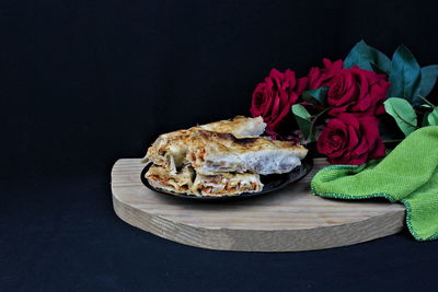 Close-up of roses on table against black background