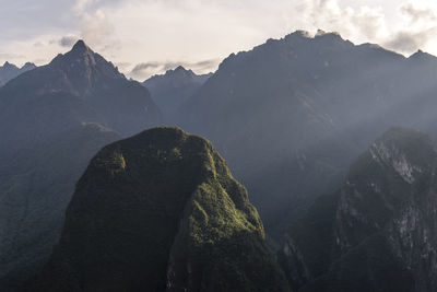 Scenic view of mountains against cloudy sky