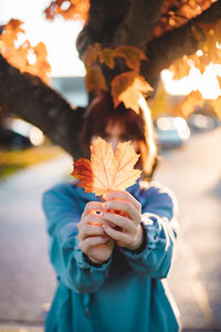 Cropped hand holding autumn maple leaf canada 