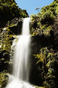 Scenic view of waterfall against sky