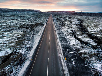 Aerial view of road amidst landscape against sky during sunset