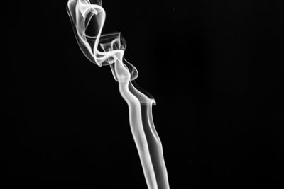 Close-up of white candle against black background