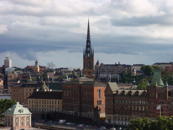 View of cityscape against cloudy sky