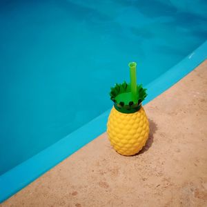 High angle view of yellow pineapple cup next to the pool