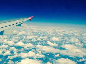 Cropped image of airplane flying over clouds