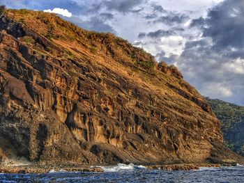 Scenic view of mountain by sea against sky