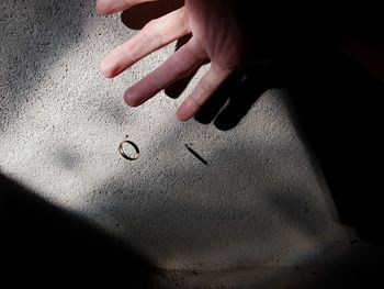 High angle view of hands on sand