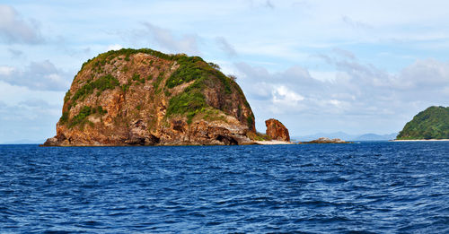 Rock formation in sea against sky