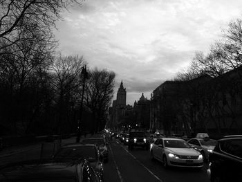 Cars on road against cloudy sky