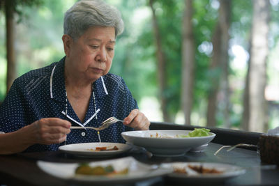 Portrait of senior woman having food at restaurant