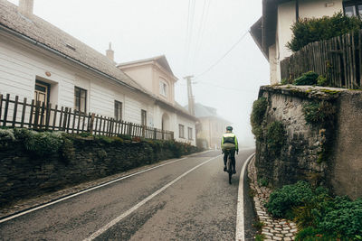 Rear view of man walking on street in city