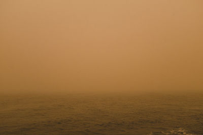 Scenic view of sea against orange sky