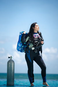 Full length of woman standing against sea and sky