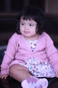 Portrait of cute girl sitting outdoors