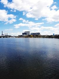 Sea by buildings against sky in city