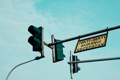 Low angle view of road sign against sky