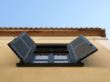 Directly below shot of window of building against clear sky