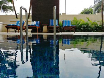 Swimming pool by lake against buildings